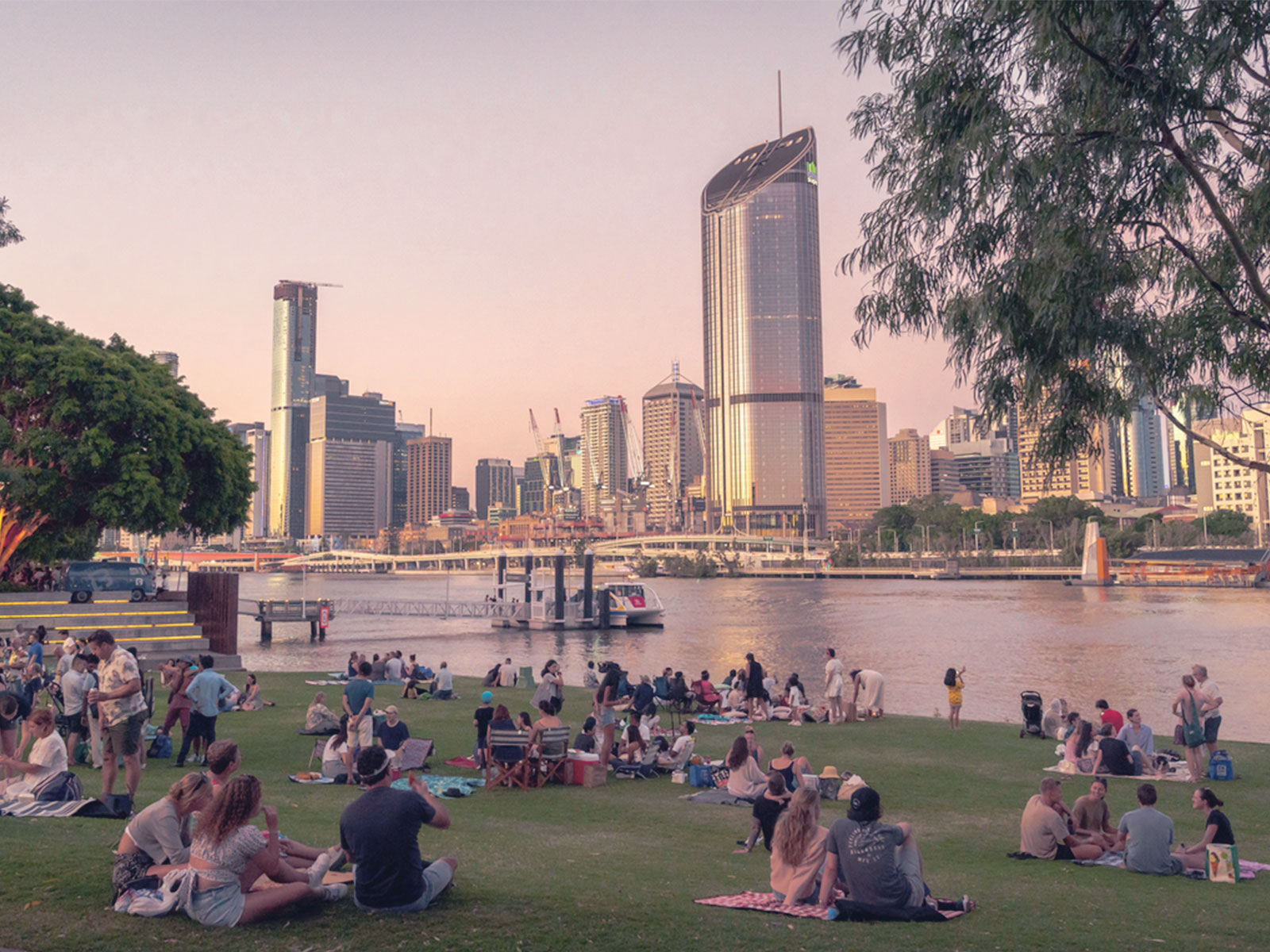 People having a picnic overlooking the Brisbane city skyline