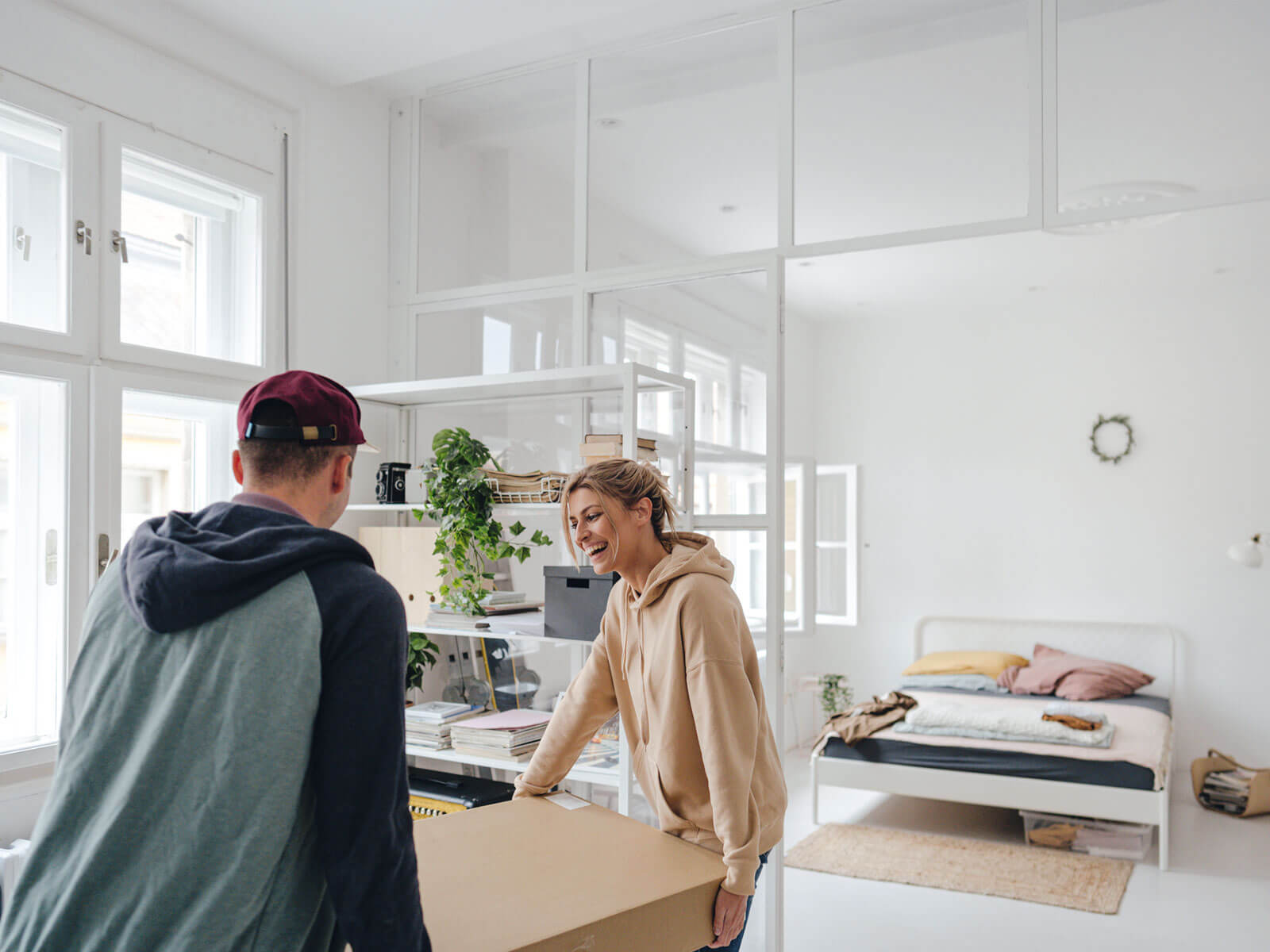 Two people moving a box into an apartment.