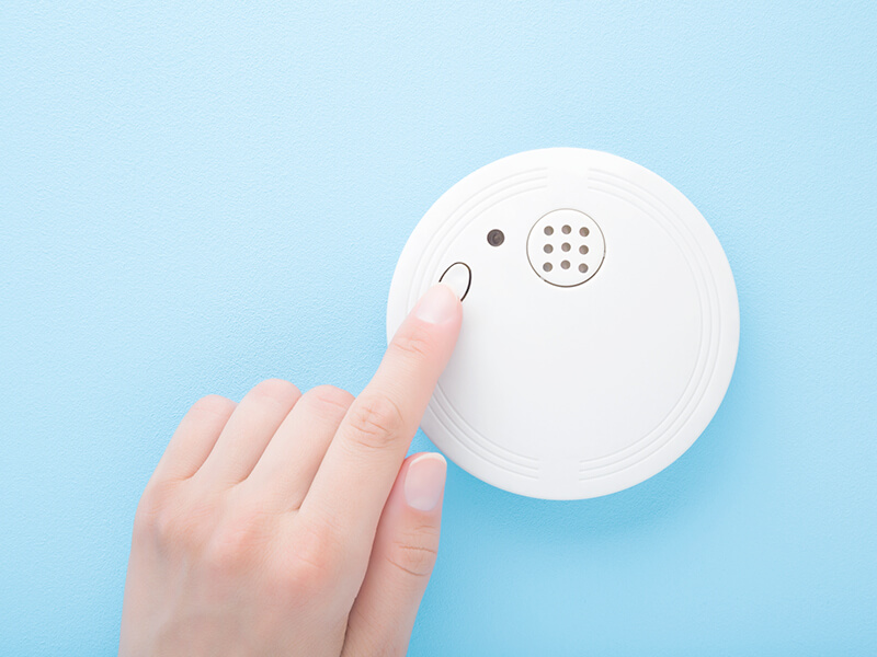 Woman turning on smoke alarm