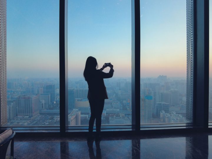 Woman taking photo at an observation deck.